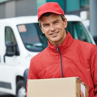 Mitchell's NY courier delivering a package in New York City with delivery truck in background.