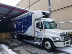 A Mitchell’sNY Logistics truck backing into the loading dock of a Northeast retailer.