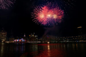 Fireworks light up the night sky over the New York City skyline and waterfront.
